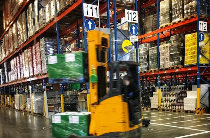 Forklift moving pallets in a warehouse aisle